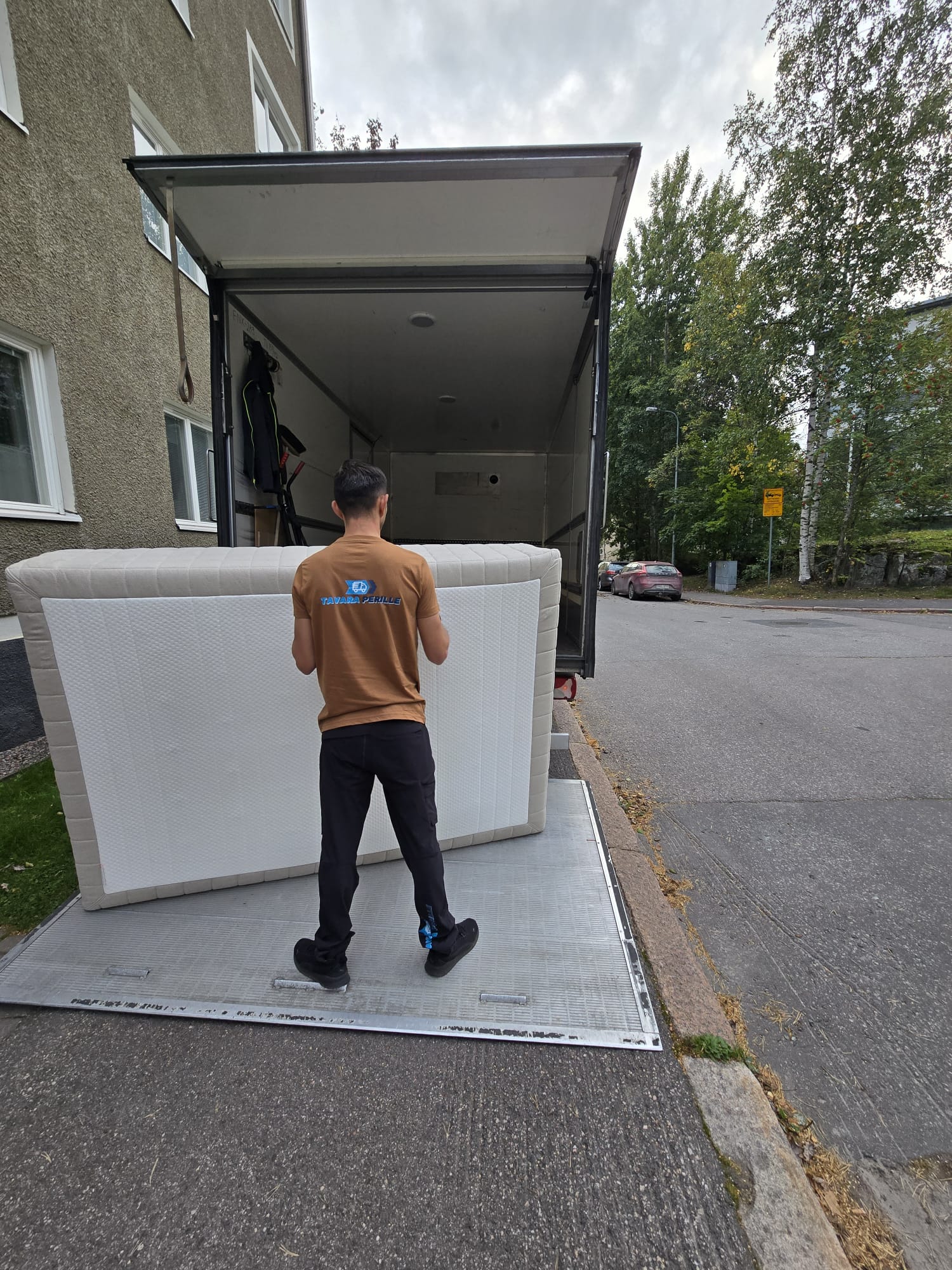Sohvan kuljetus – ammattilainen lastaa sohvaa muuttoautoon